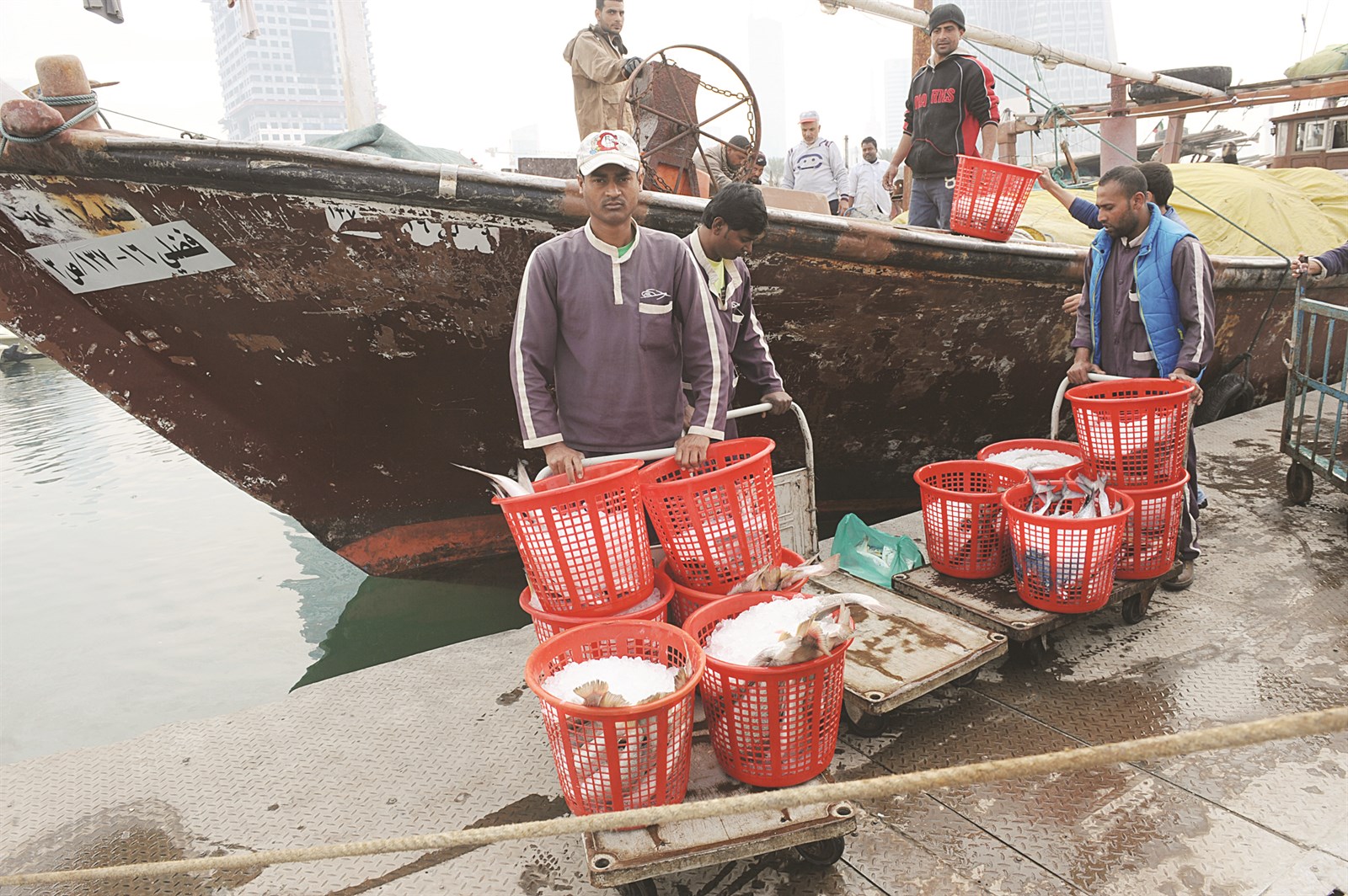 صيادون يفرغون حصيلة صيدهم من المياه الكويتية