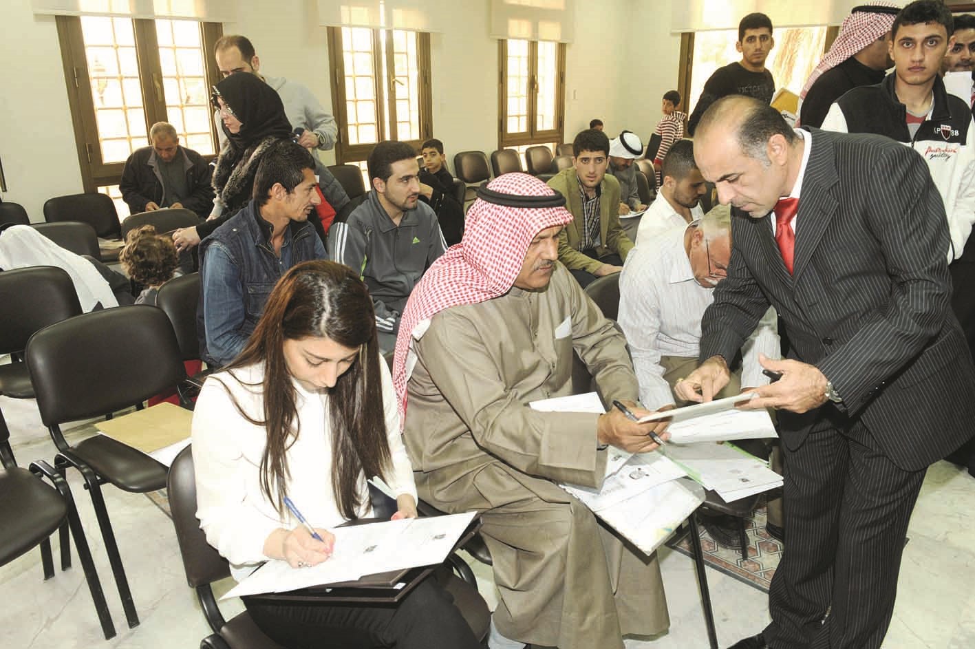 أحد موظفي السفارة يساعد مراجع على إنجاز معاملته