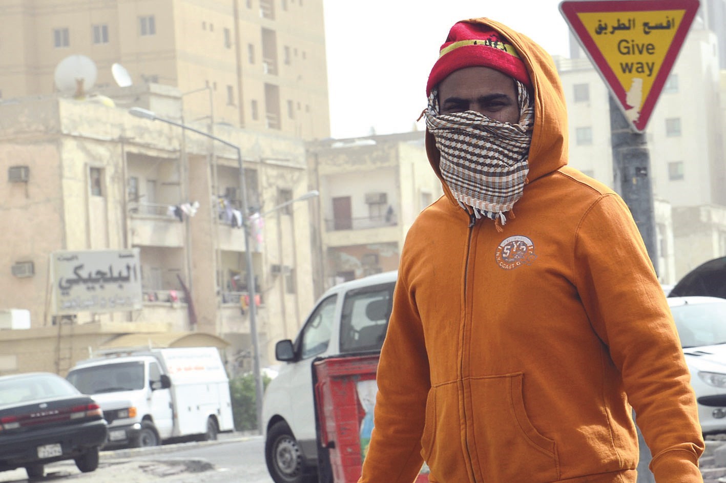 عامل آسيوي يرتدي القناع تجنّباً لمخاطر الجو المضطرب