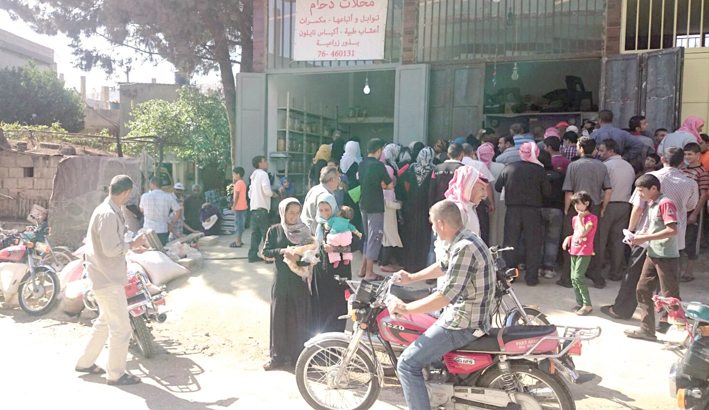 سوريون أمام مركز توزيع المساعدات في عرسال