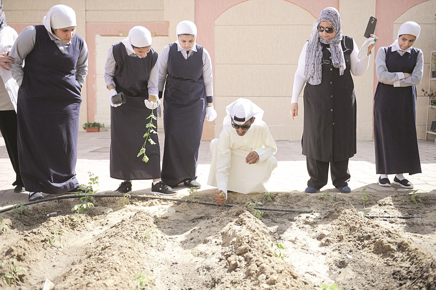 طالبات يتابعن العازمي خلال زراعة «المورينغا»
