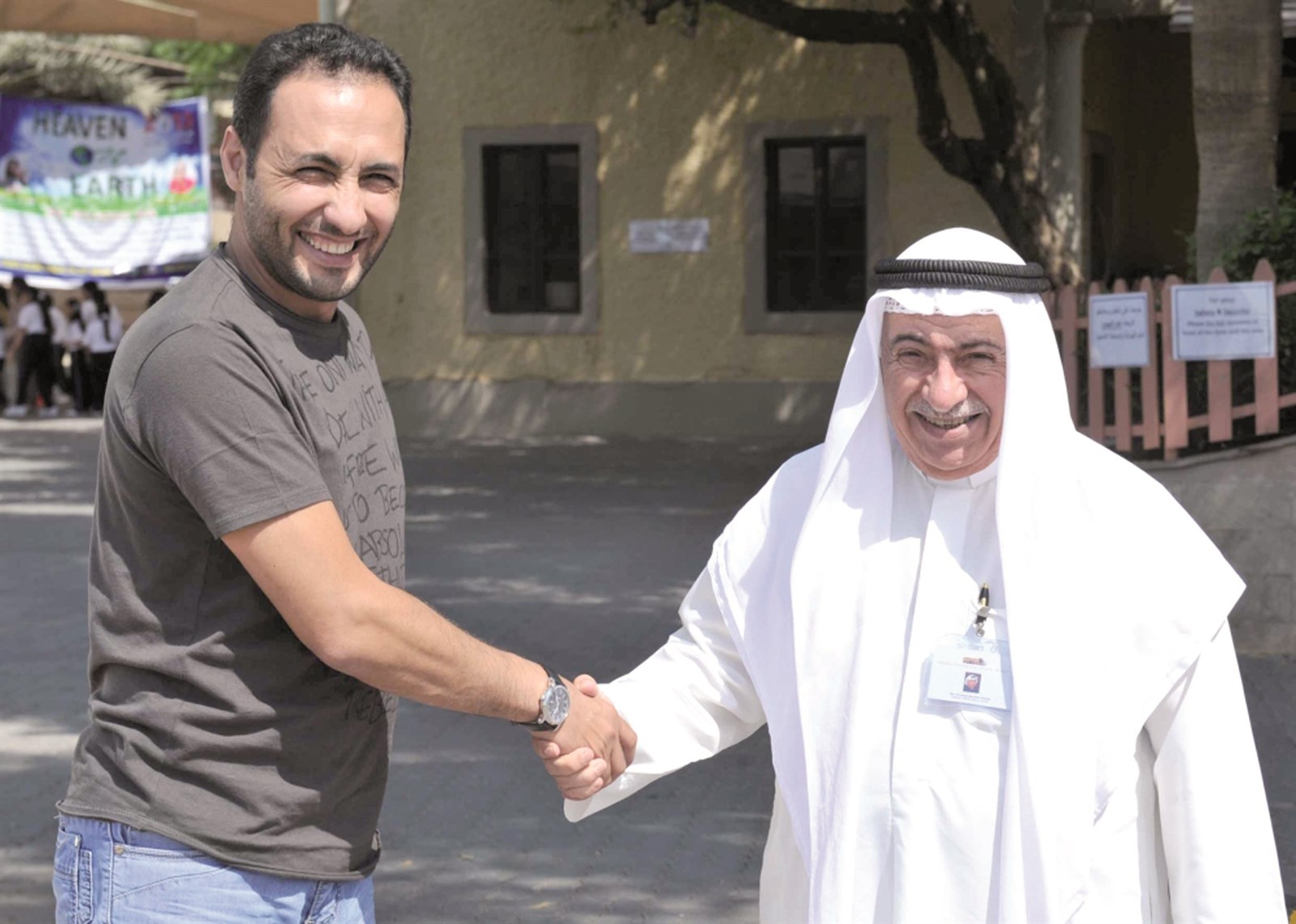 غريب مصافحاً الزميل أحمد زكريا في ساحة الكنيسة