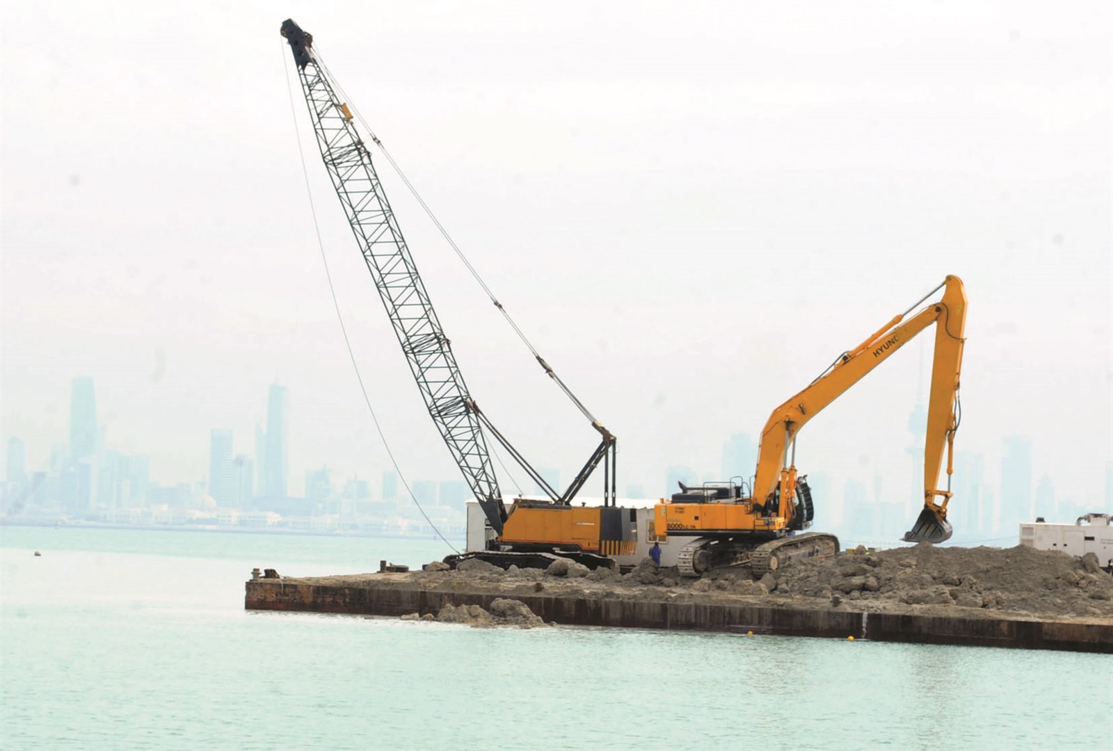 آليات في عرض البحر لوضع قواعد جسر جابر