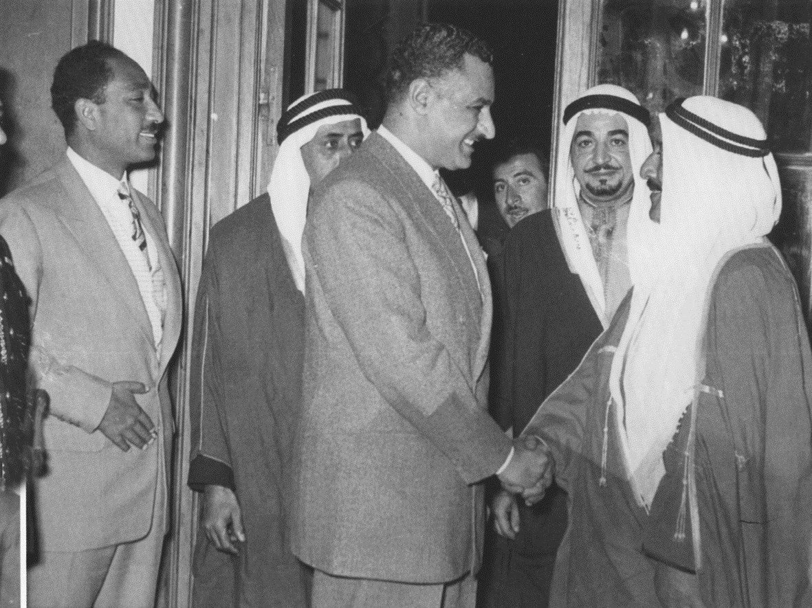 مصافحا الرئيس جمال عبد الناصر ويظهر عزت جعفر ومحمد أنور السادات