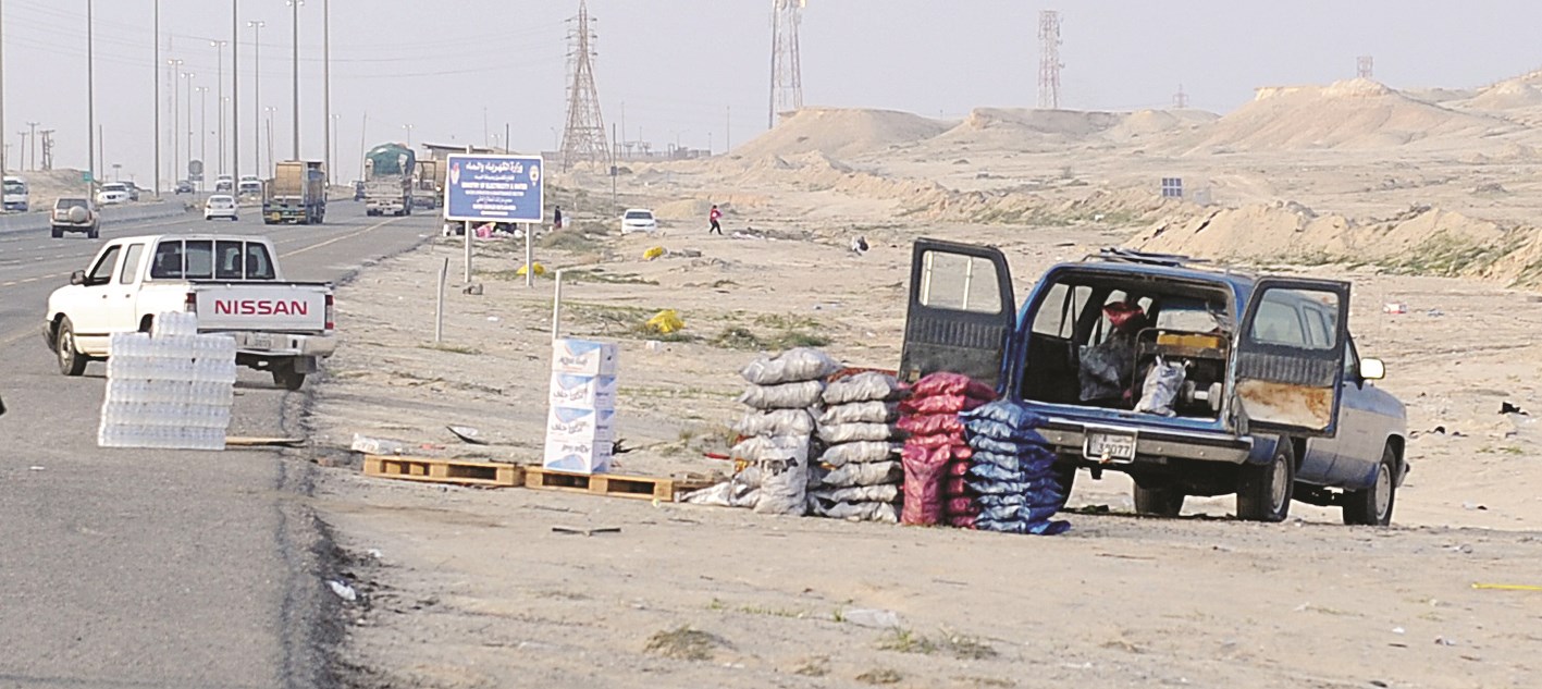 سيارة دفع رباعي وبجانبها مياه وفحم للبيع