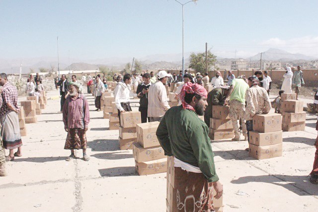 يمنيون يتسلمون مساعدات الهلال الأحمر