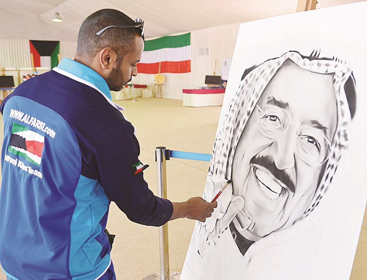 شاب يضع اللمسات الأخيرة على صورة سمو الأمير  (تصوير موسى عياش)