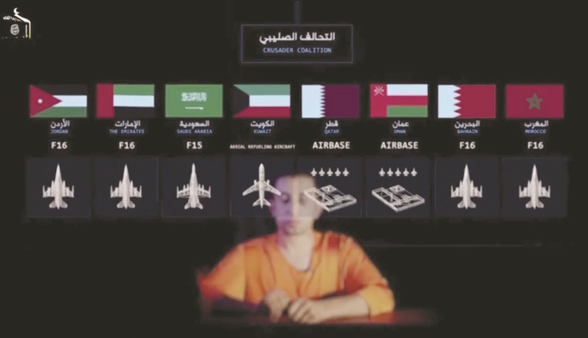الطيار الأردني قبيل إعدامه وخلفه أعلام دول التحالف العربية وبينها الكويت