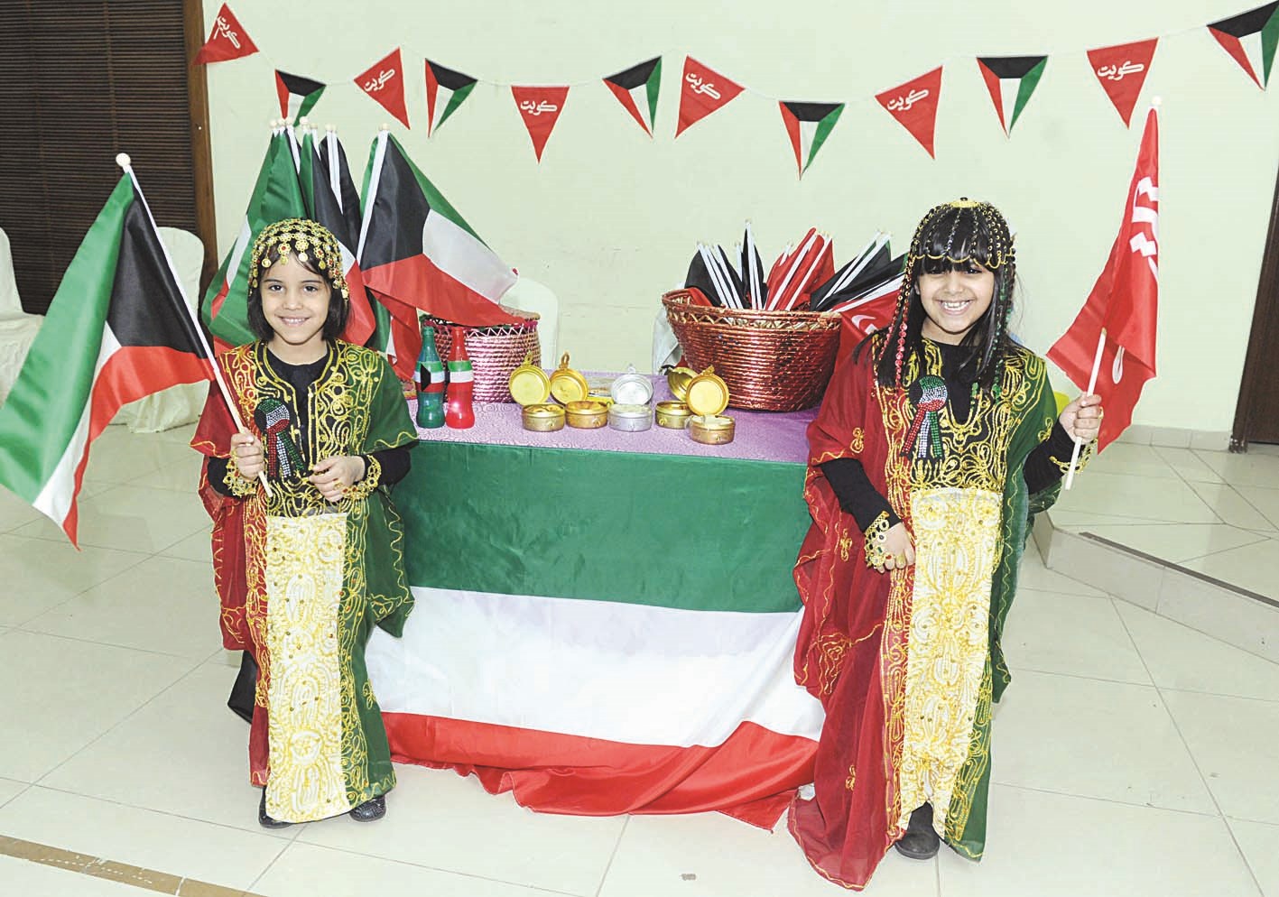 طفلتان تحملان علم الكويت خلال الحفل