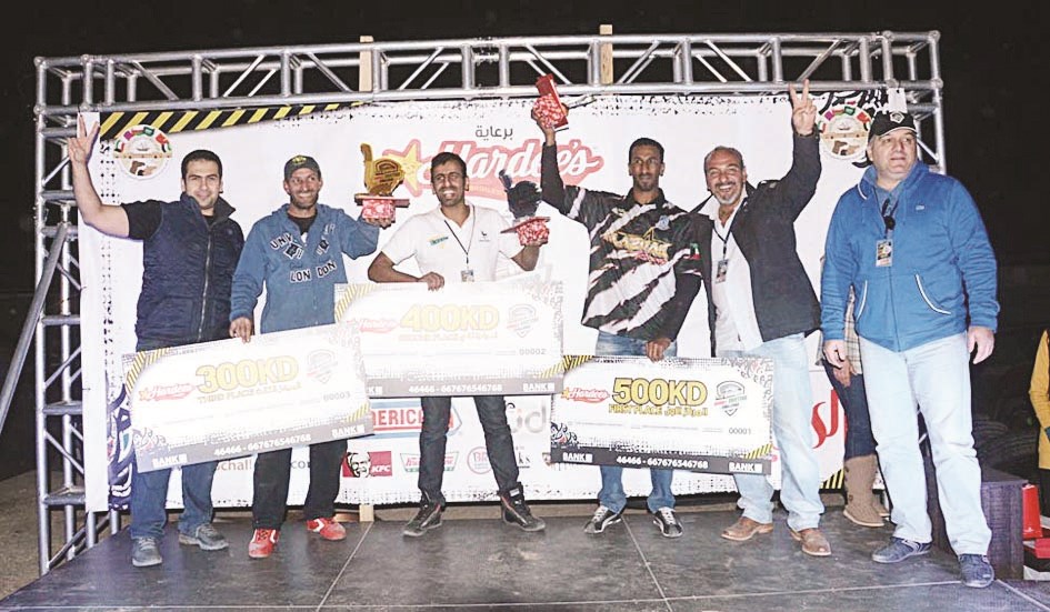 الفائزون بالمراكز الأولى مع عدد من أعضاء اللجنة المنظمة على منصة التتويج