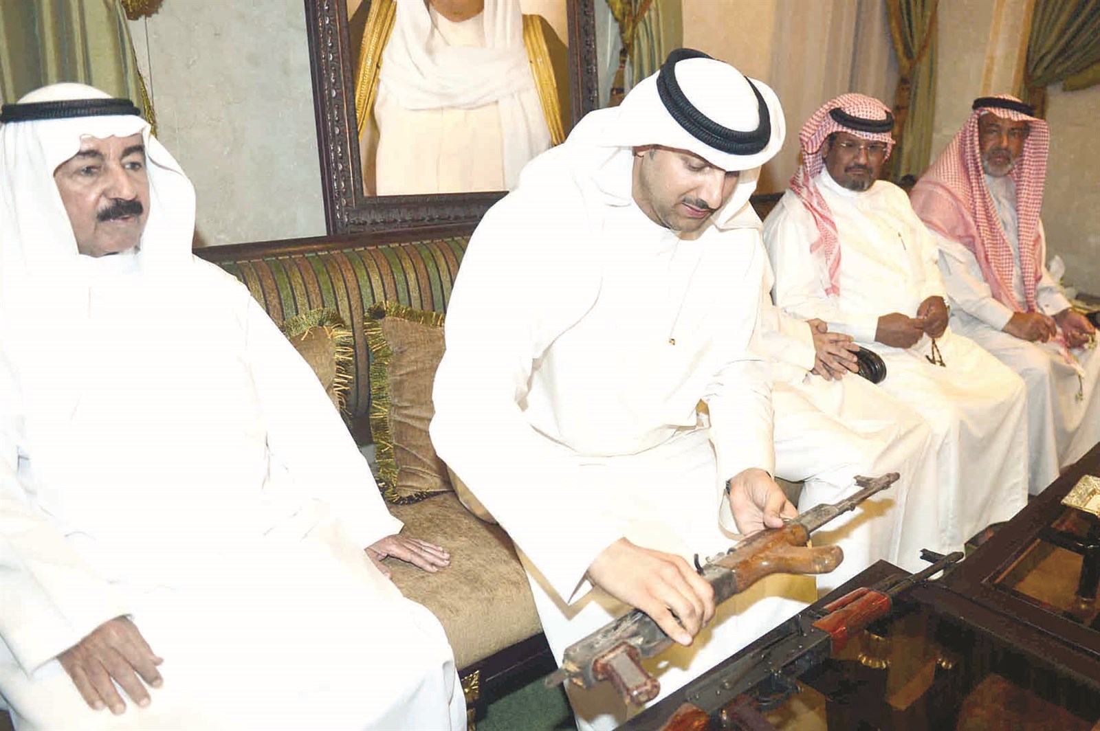 الحساوي متسلماً سلاحاً رشاشاً وإلى جانبه بن حثلين