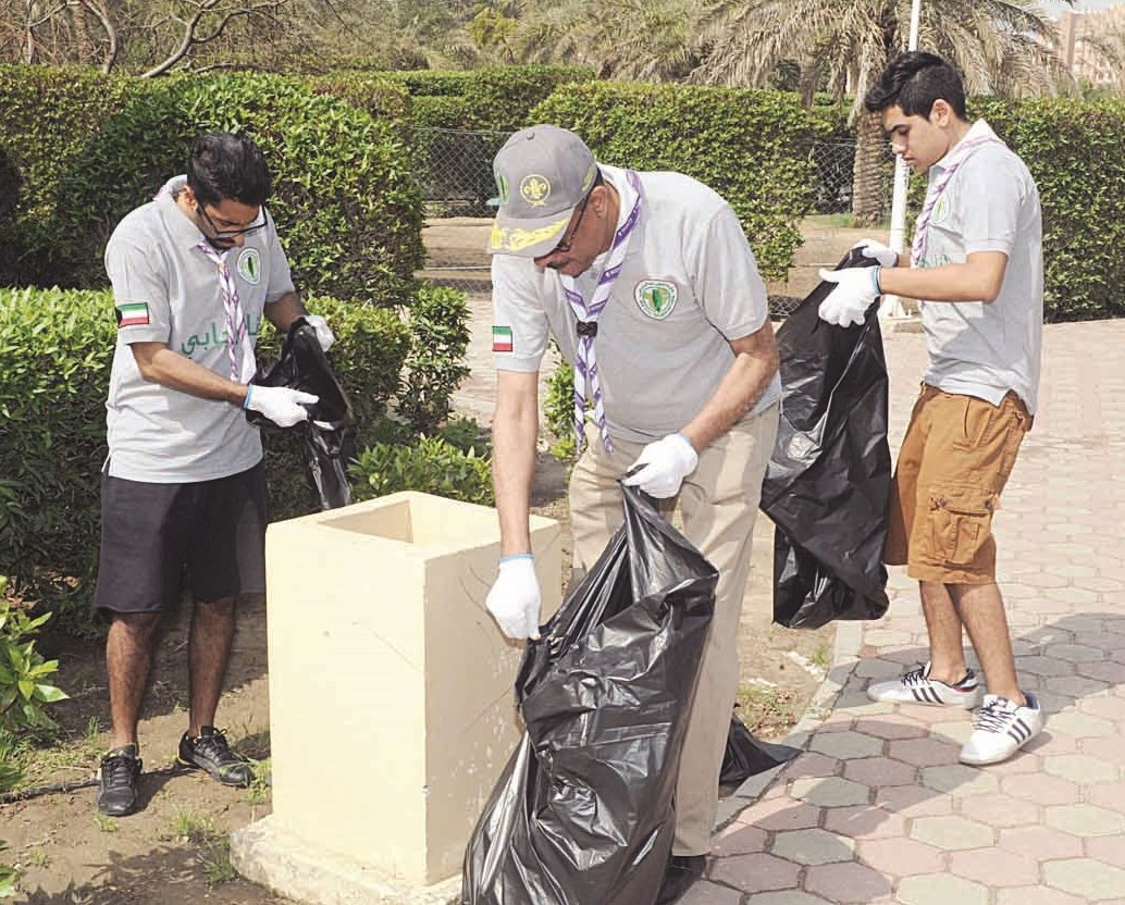 فريق الكشافة يجمع القمامة من ممرات الحديقة