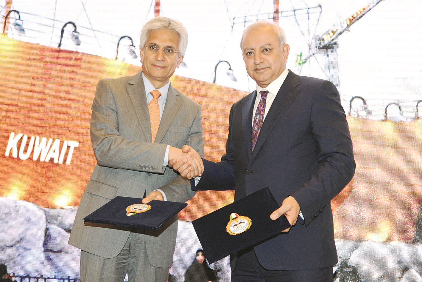 العيسى وميرزا يتبادلان نسخ الاتفاقية (تصوير كرم ذياب)