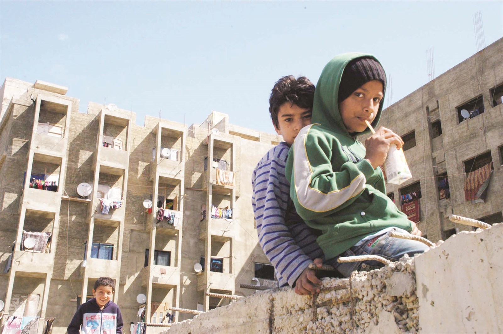 طفلان نازحان يشربان العصير أمام المجمّع