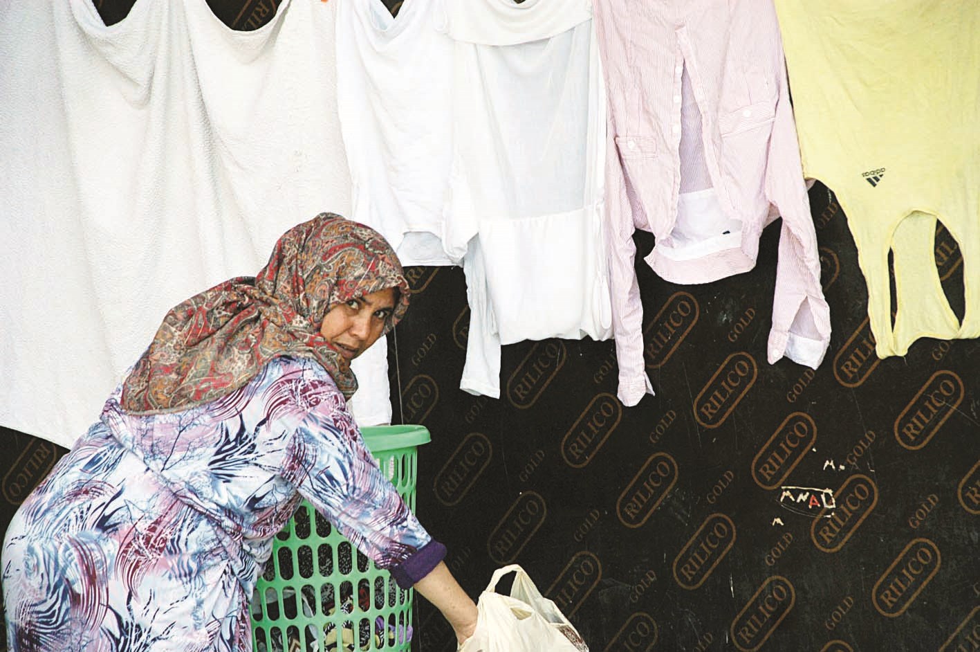 نازحة تقوم بنشر غسيل الثياب