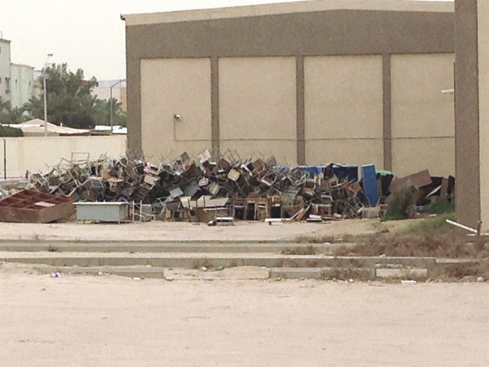 مدرسة تخزن أثاثها في ساحة لا يحميها إلا سور حديد