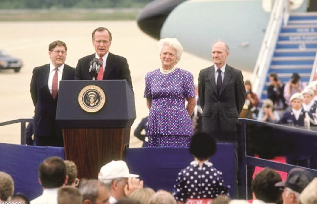 بوش خلال مؤتمر صحافي وتبدو ع زوجته باربرا إلى يساره بينما يبدو سنونو في الخلف على يسار الصورة