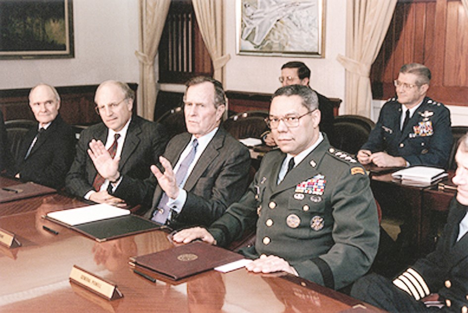 بوش الأب خلال عملية عاصفة الصحراء في 1991 ويبدو عن يساره الجنرال كولن باول وعن يمينه وزير دفاعه ديك تشيني ومستشاره للأمن القومي برينت سكوكروفت