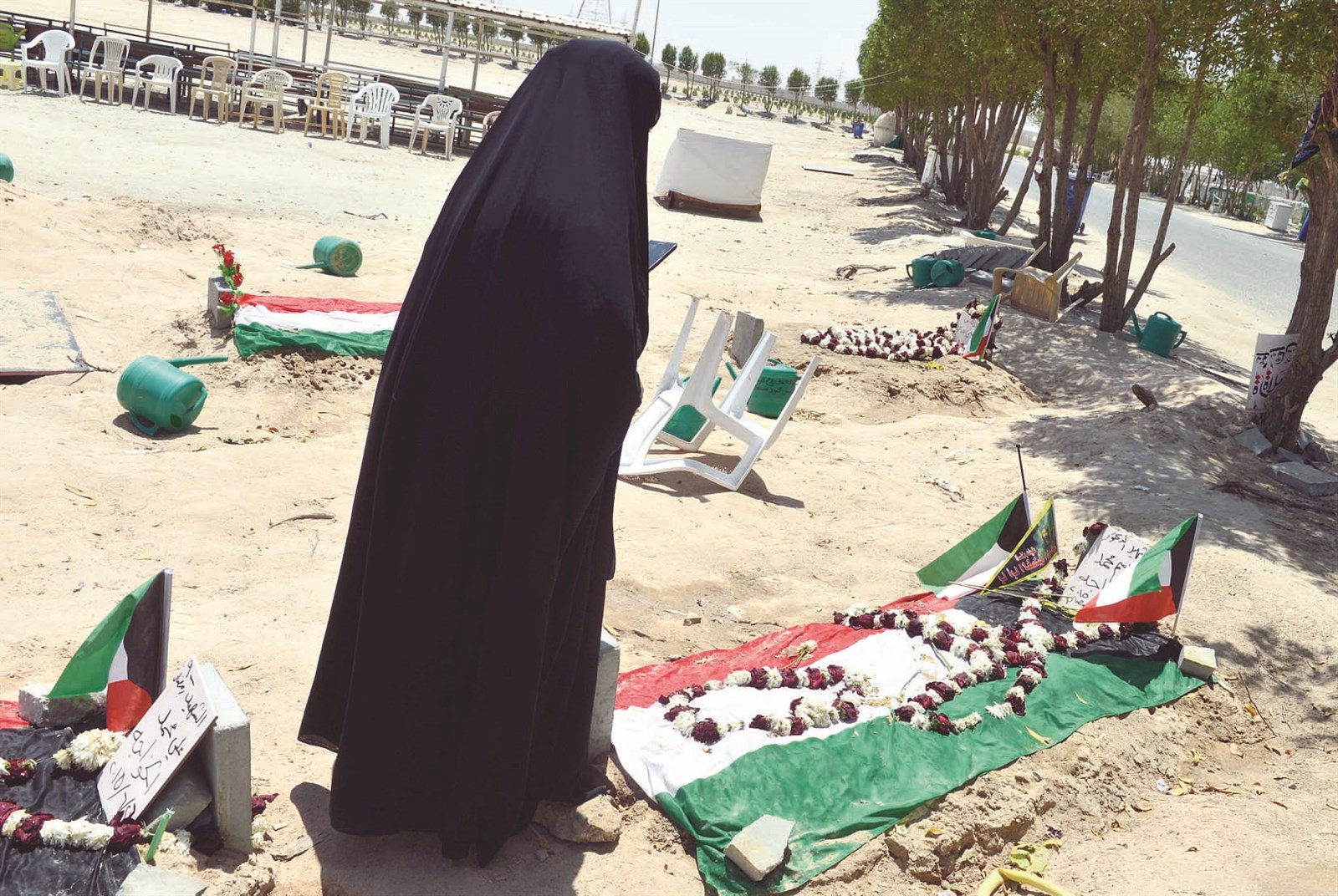 علم الكويت وورود تزين قبر أحد الشهداء (تصوير موسى عياش)