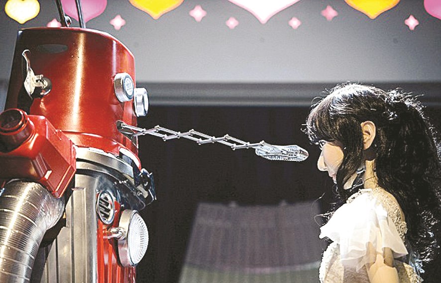 العريس يوجه قرصاً مدمجاً (سي دي) إلى فم عروسته الروبوتية... على سبيل القُبلة!