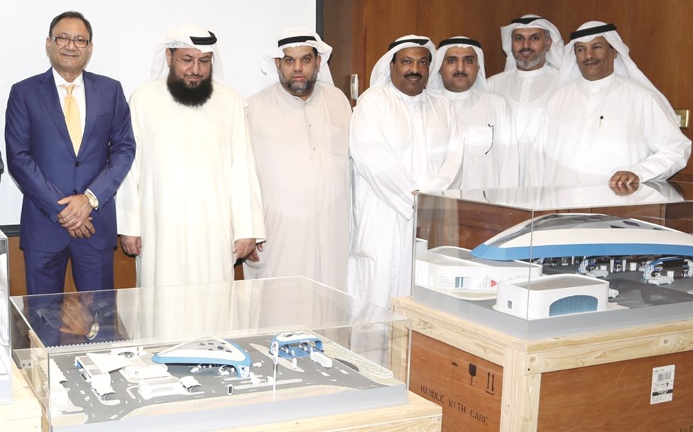 المحروس وبورسلي مع مسؤولي «التسويق المحلي» لحظة الكشف عن المجسم الجديد لمحطات الوقود المستقبلية