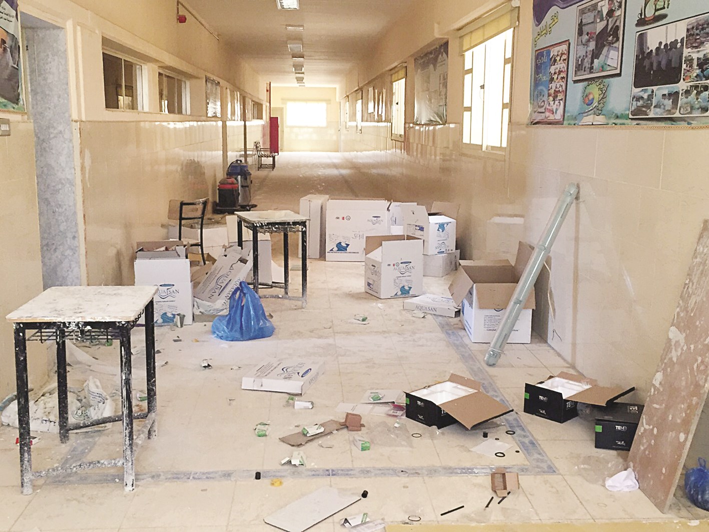 كراتين وأصباغ ومهملات في ممر المدرسة