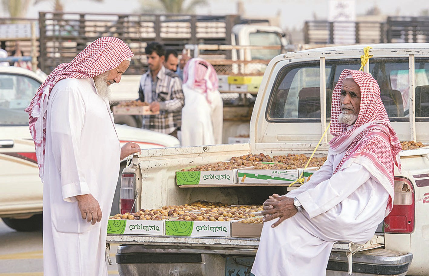 بائع أمام حصيلة من التمر