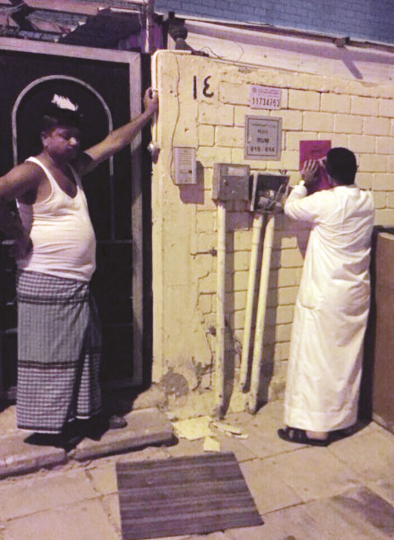 عازب يتابع وضع علامة تحذيرية بالإخلاء على المنزل الذي يقطنه