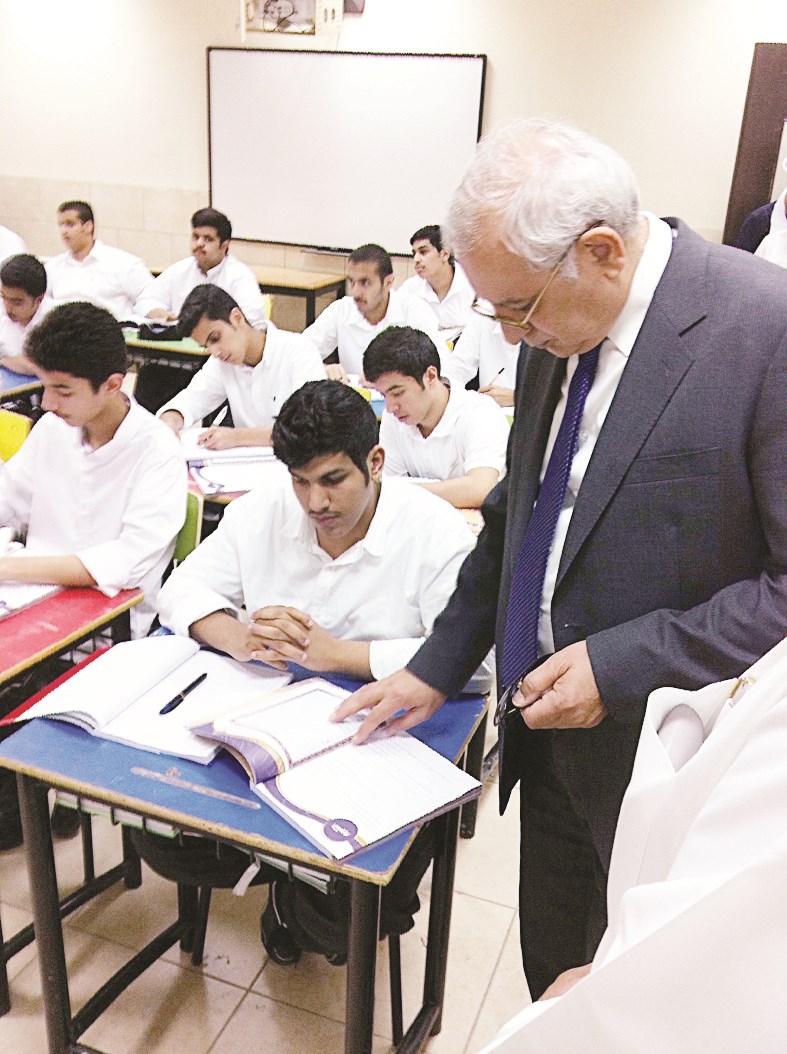 ...ويتابع ما يتلقاه الطلاب من معلومات في أحد الكتب