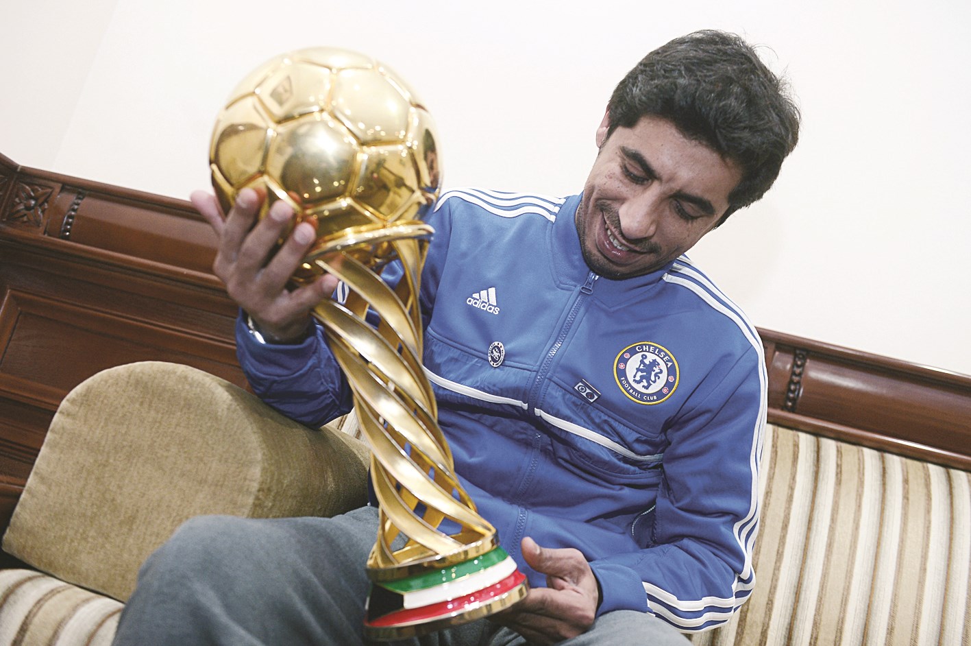 سلمان عوّاد يتأمل كأس سمو ولي العهد في ديوانية «الراي»   (تصوير أسعد عبدالله)