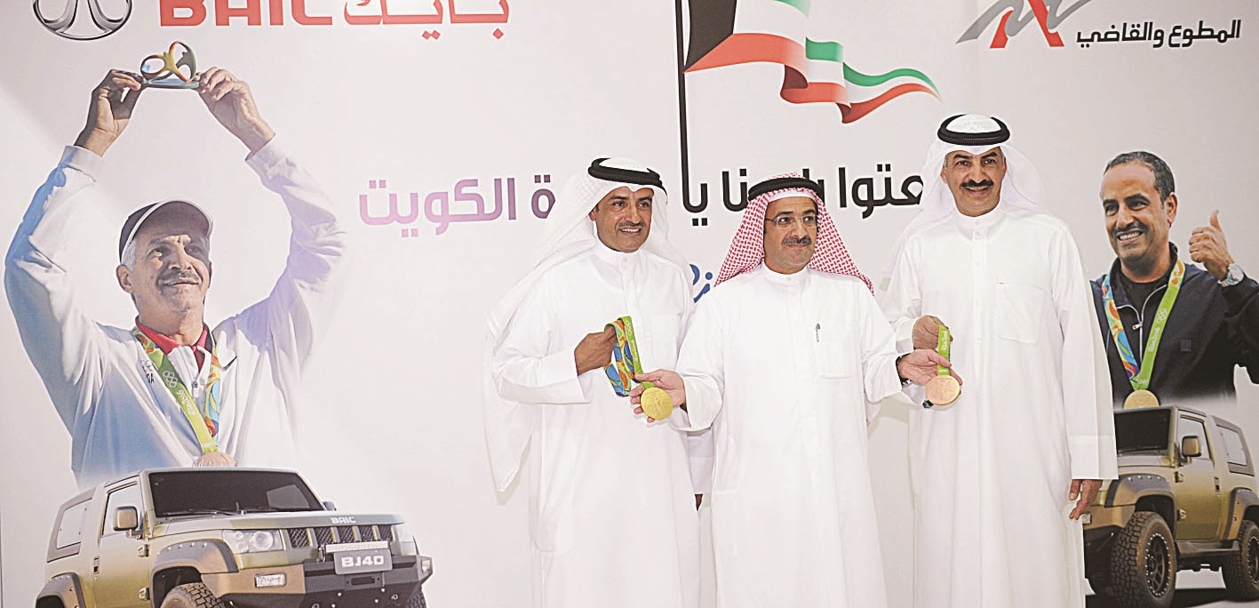 عمر القاضي متوسطاً البطلين فهيد الديحاني وعبدالله الرشيدي