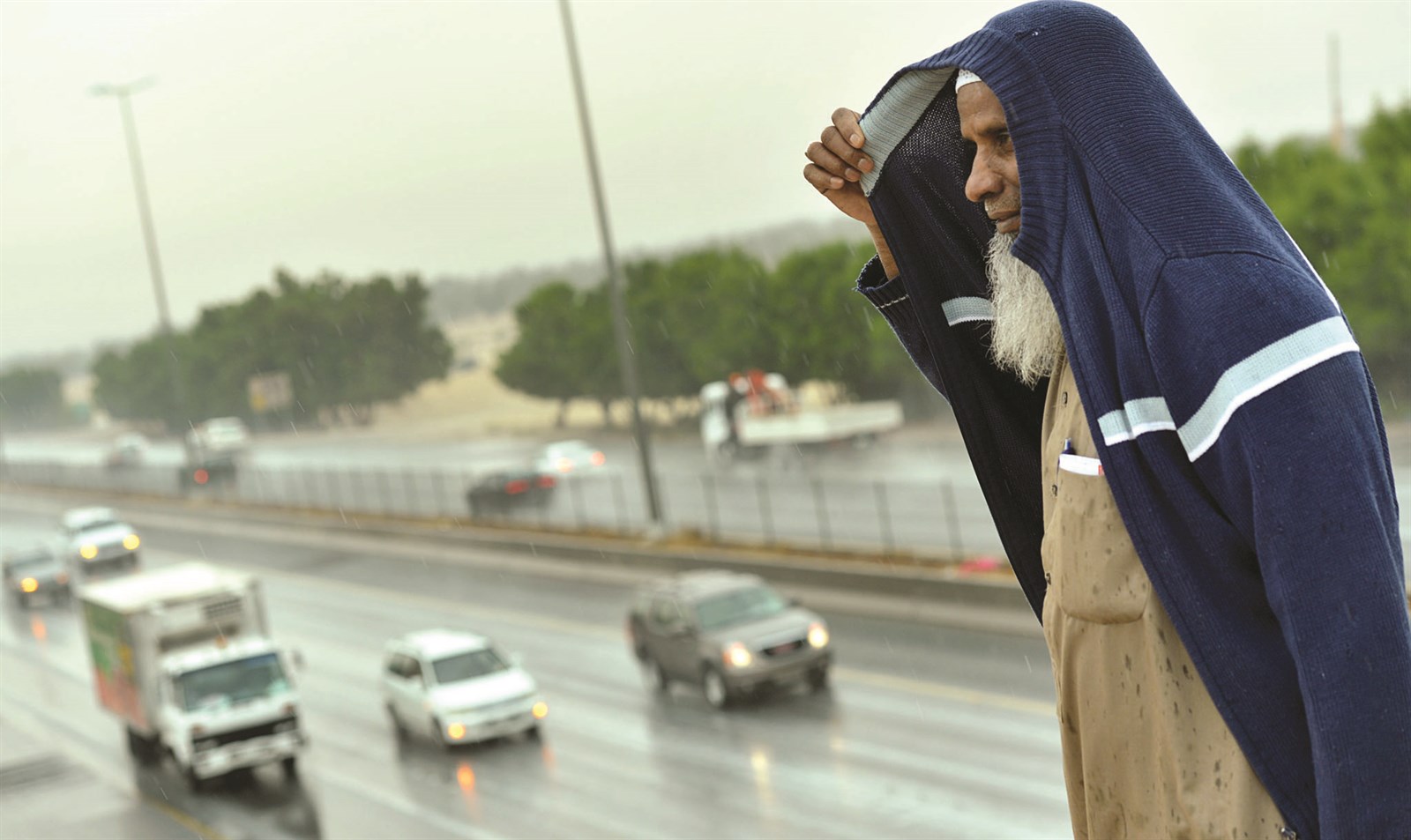 فوق جسر المشاة تحولت الجاكيت إلى مظلة