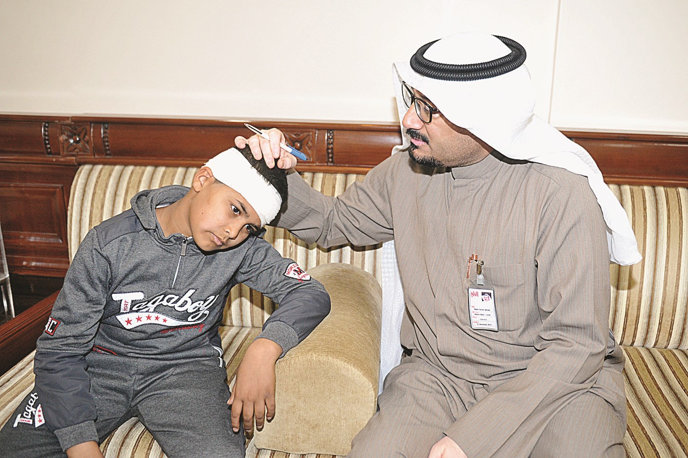 الزميل ناصر الفرحان يعاين رأس الطالب المصاب  (تصوير نور هنداوي)