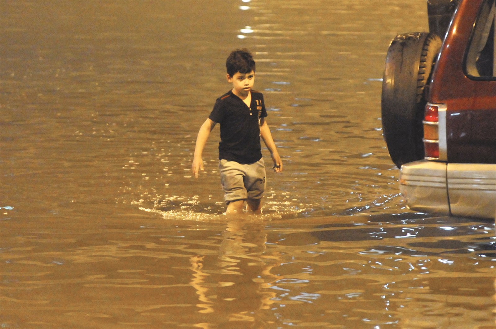 طفل... هل يستمتع بالماء أم يساعد السيارة العالقة؟!