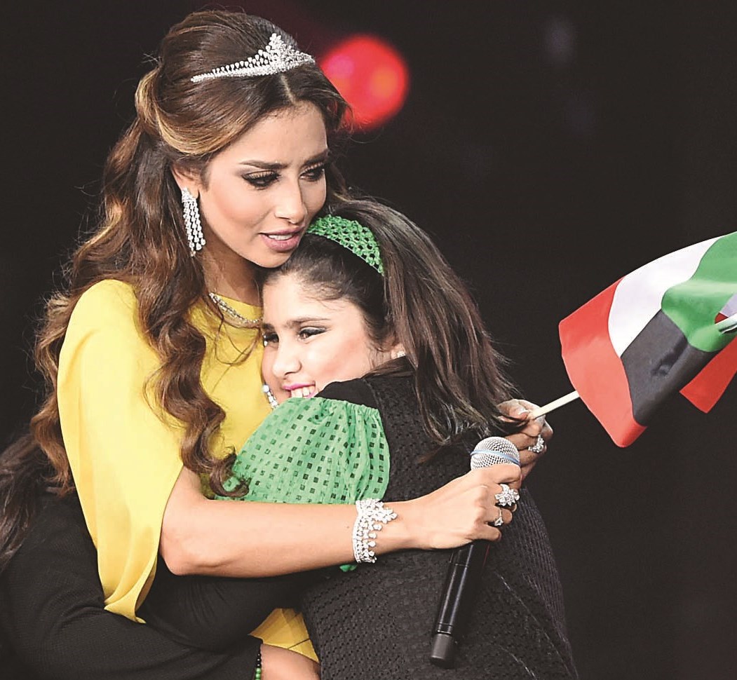 بلقيس تحتضن طفلة