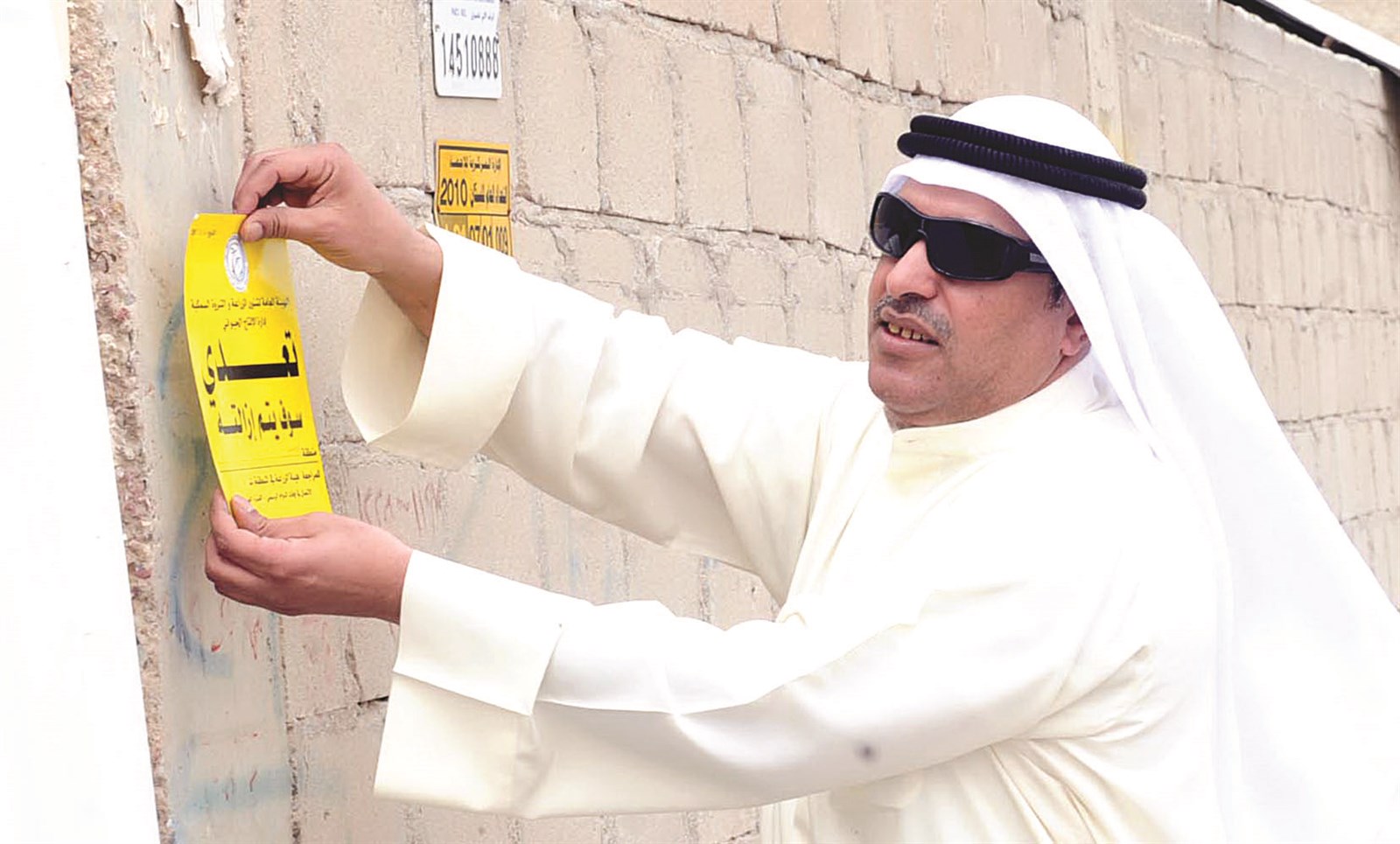العدواني يلصق إنذاراً على بوابة مزرعة مخالفة