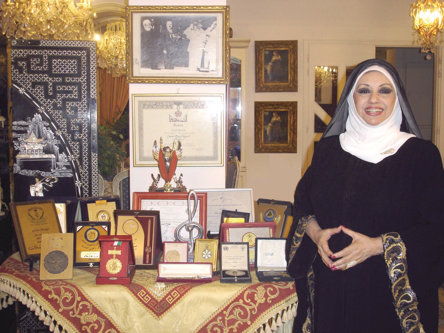 سلام أمام قسم من شهادات التكريم والدروع وتبدو صورة جدها الشيخ عبدالرحمن سلام لدى زيارة المفوض السامي الفرنسي لدار الفتوى