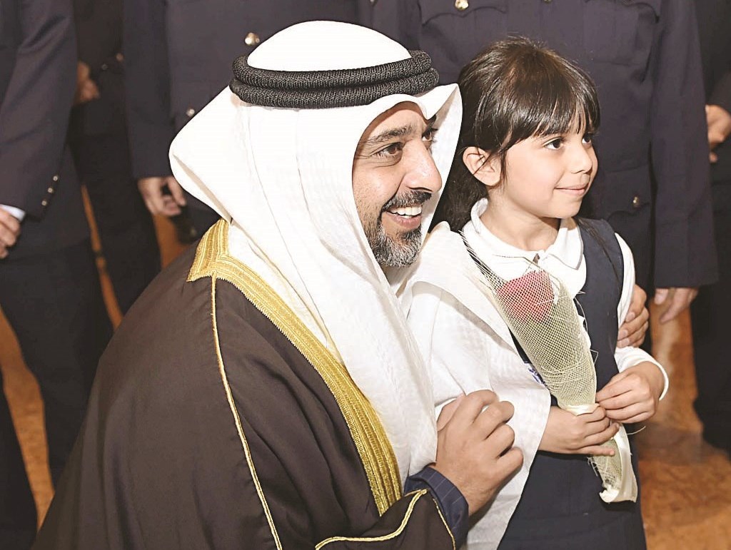 العبدالله في صورة مع طفلة قبل إهدائه وردة