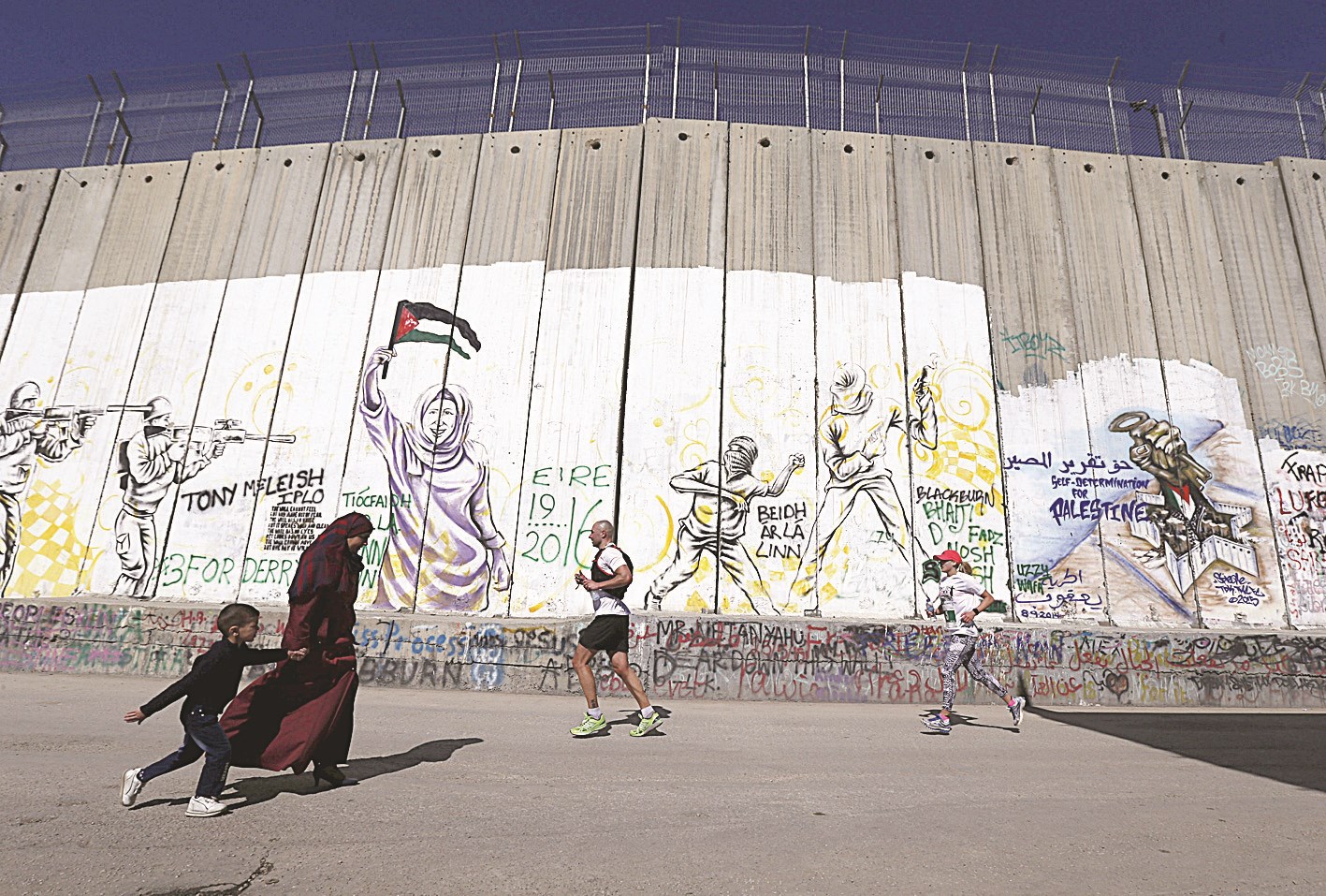 u0641u0644u0633u0637u064au0646u064au0629 u0648u0627u0628u0646u0647u0627 u0648u0645u0634u0627u0631u0643u0627u0646 u0641u064a u00abu0645u0627u0631u0627u062bu0648u0646 u0641u0644u0633u0637u064au0646u00bb u064au0645u0631u0651u0648u0646 u0623u0645u0627u0645 u0627u0644u062cu062fu0627u0631 u0627u0644u0639u0627u0632u0644 u0641u064a u0628u064au062a u0644u062du0645     (u0631u0648u064au062au0631u0632)