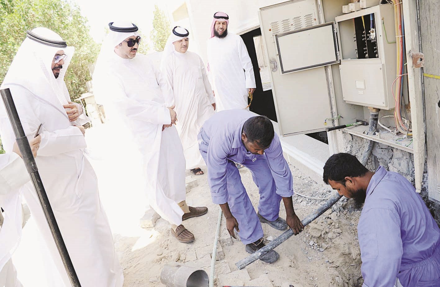 عمال البلدية يسحبون الكيبل بمشاركة «الكهرباء» (تصوير نايف العقلة)