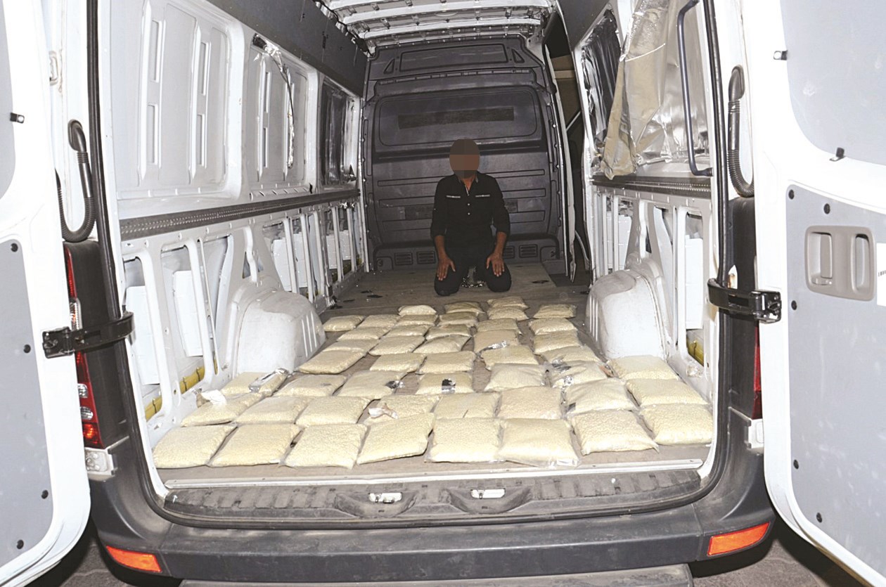 المتهم وأمامه المضبوطات