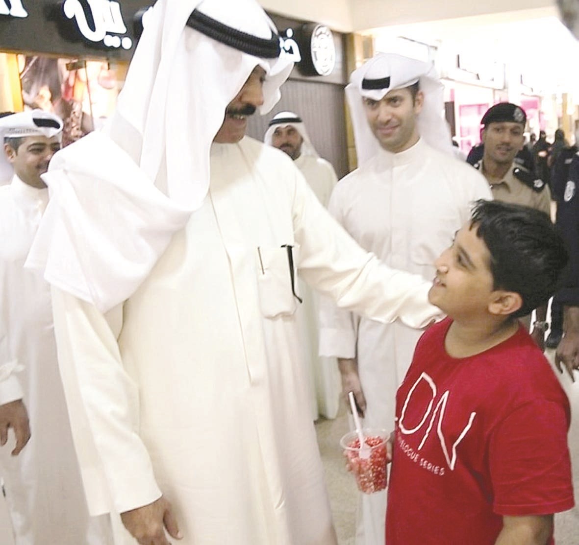 الخالد يحادث طفلاً خلال الجولة في المجمع التجاري