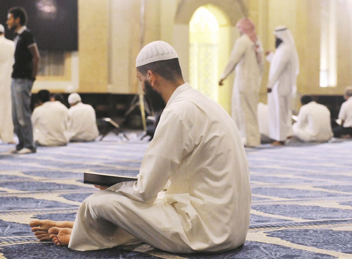 مصل يقضي وقت الانتظار في تلاوة القرآن