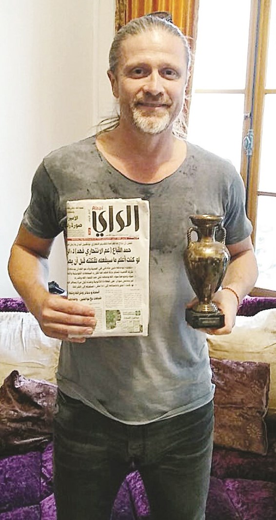 بوتي في منزله حاملاً مجسماً لكأس أوروبا وعدداً من جريدة «الراي»