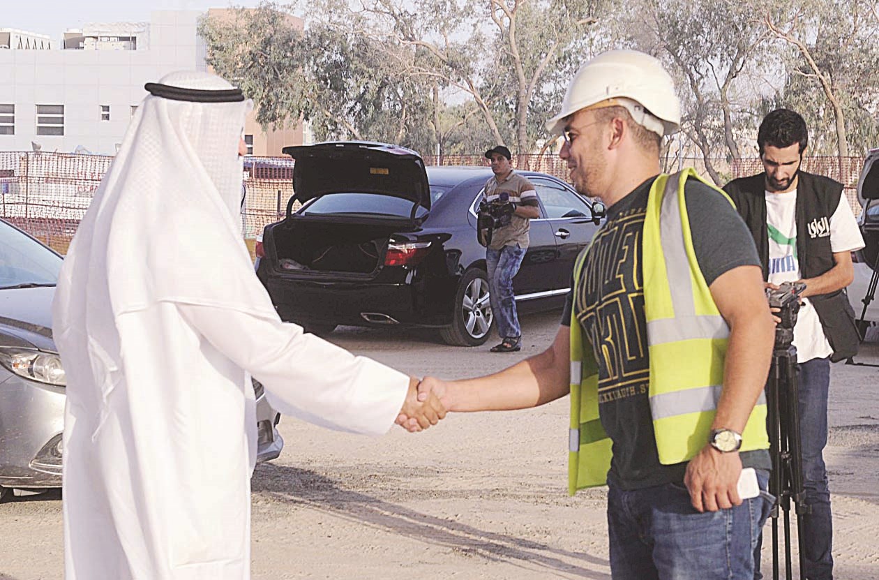 وزير الأشغال يصافح أحد مهندسي مشروع طريق الجهراء