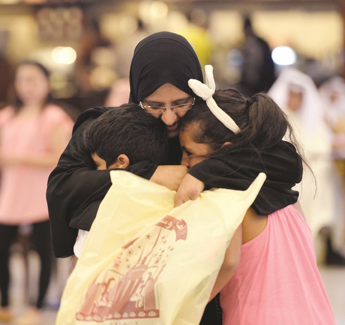 أم تحتضن ابنيها بعد الوصول