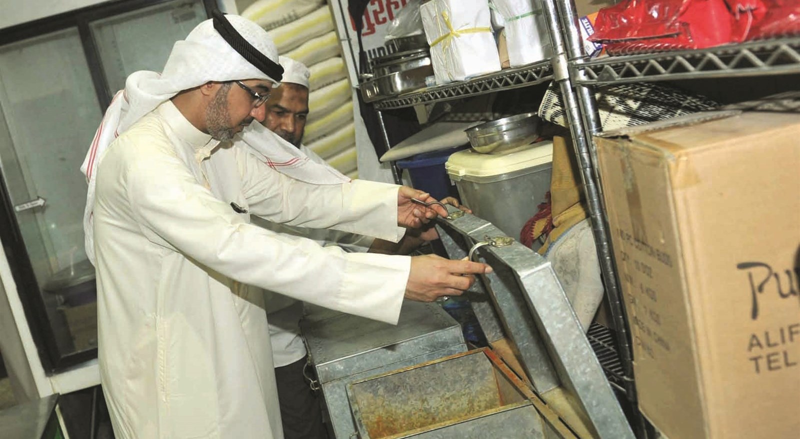 الحافظ مدققا على محتويات مخزن أحد المطاعم     (تصوير سعد هنداوي)