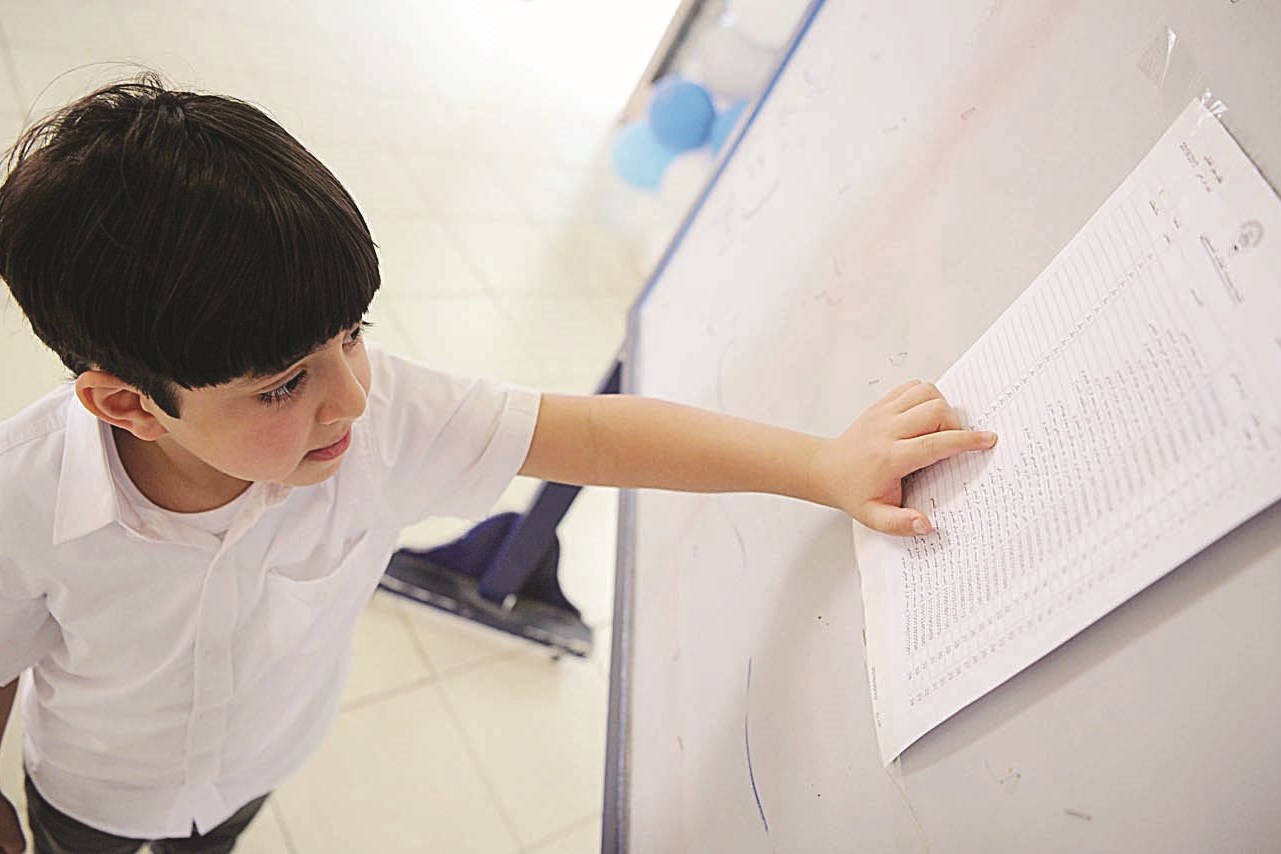 طفل يبحث عن اسمه في قائمة أحد الفصول