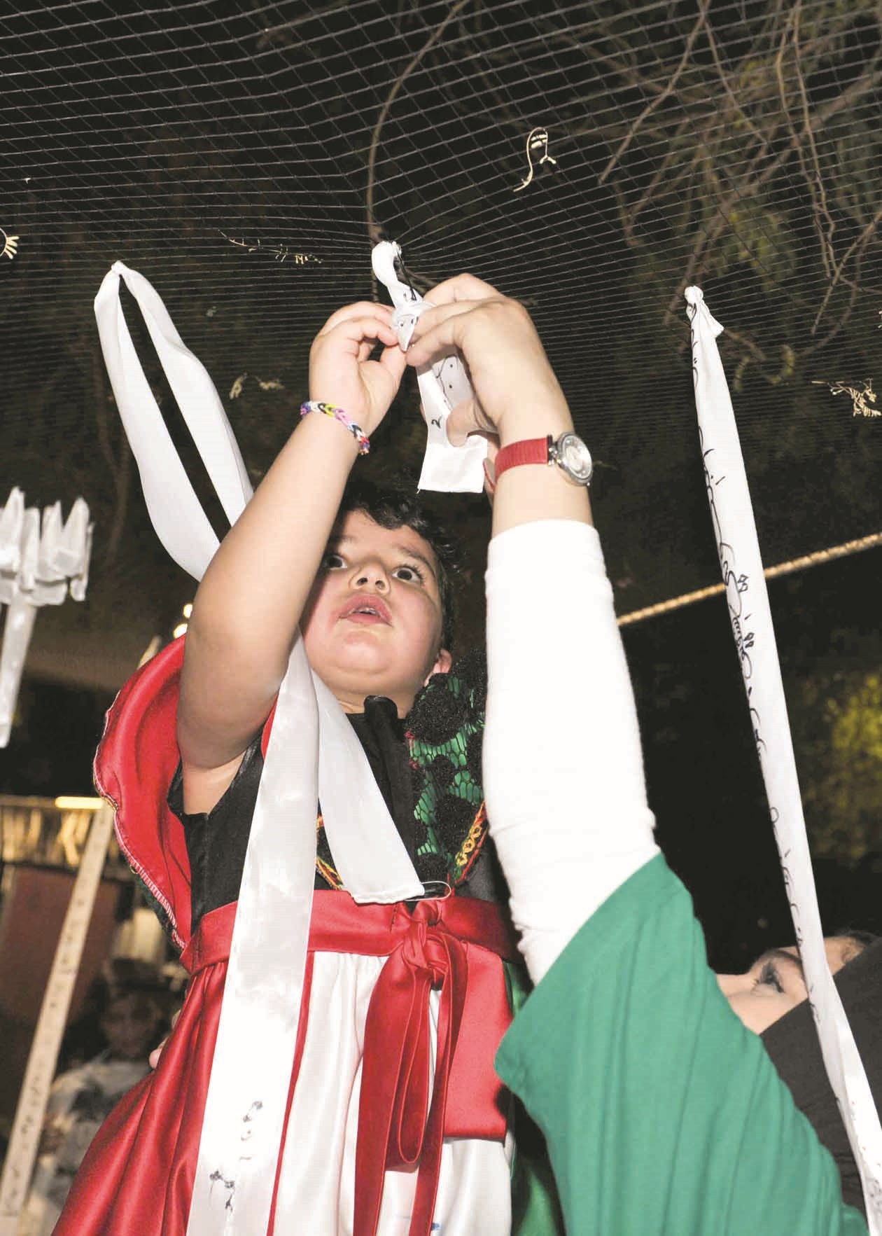 ابنة شهيد تعانق أشجار الحديقة بعبارة «كلنا كويتيون»