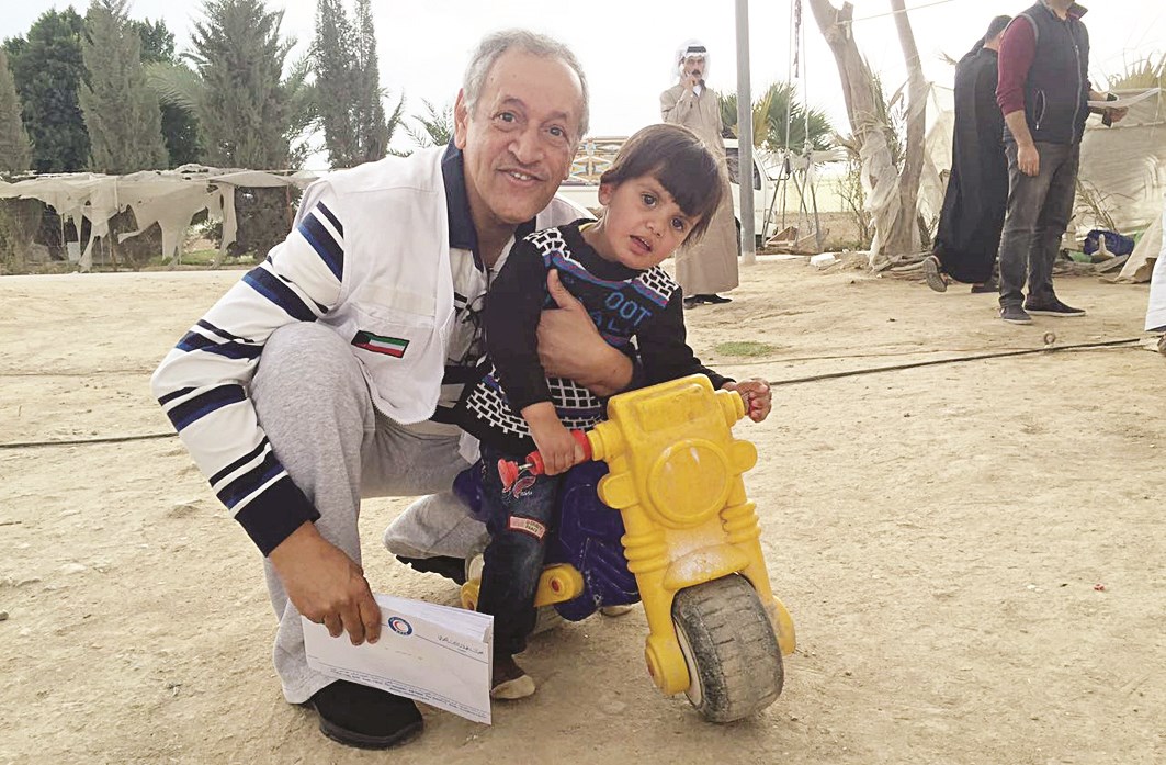 الحساوي مع أحد الأطفال اللاجئين